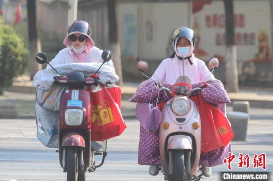 江西省南昌市の街中、日焼け防止のために完全武装してバイクで走る女性（撮影・劉力鑫）。