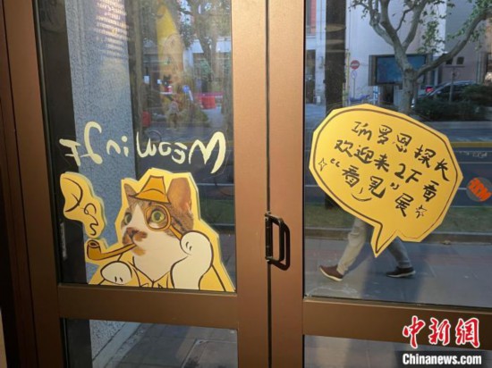 羅恩の写真を加工したイラストが貼られた喫茶店のドア（撮影・李秋瑩）。