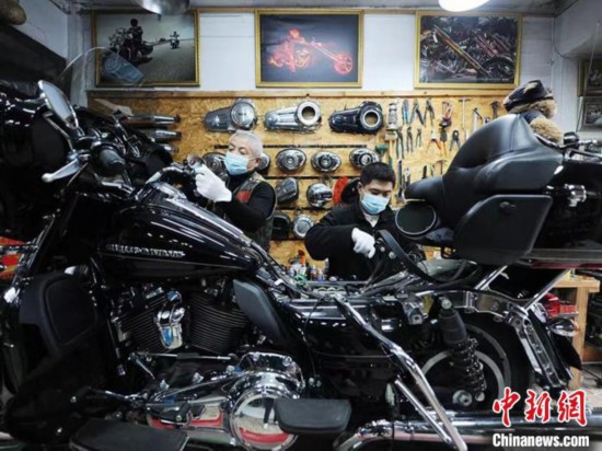 劉井成さんと息子の劉帥さんが主に修理を請け負う輸入バイクが並ぶ店内（撮影・劉棟）。