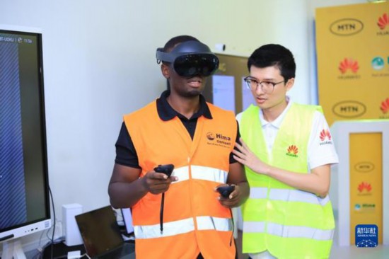 3日、ウガンダのカンパラで開かれた5Gデジタルセメント工場プロジェクトの発表会で、5G技術がもたらす拡張現実（AR）技術の運用の新しいシーンをデモンストレーションする中国のファーウェイとウガンダのHIMAセメントの代表者。（画像提供はファーウェイ）