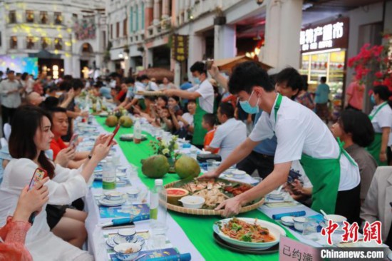 4月13日夜、海口市の騎楼老街に並べられたテーブルで食事をする人々（撮影・馮恵）。