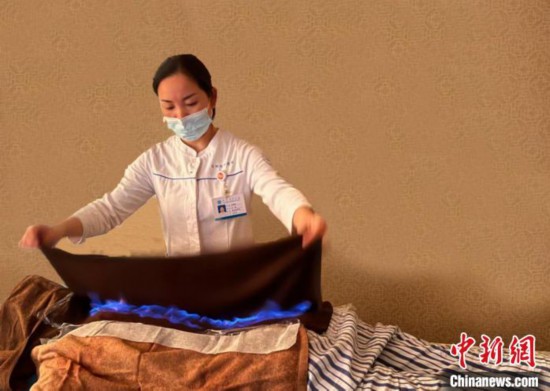 患者に伝統療法の「火竜灸」の治療を施す医療従事者。（写真提供は杭州市中医病院）