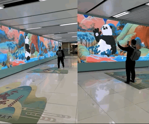 成都市の地下鉄駅に設置されている歩行者の動作を真似るパンダが写し出された液晶ディスプレイ。