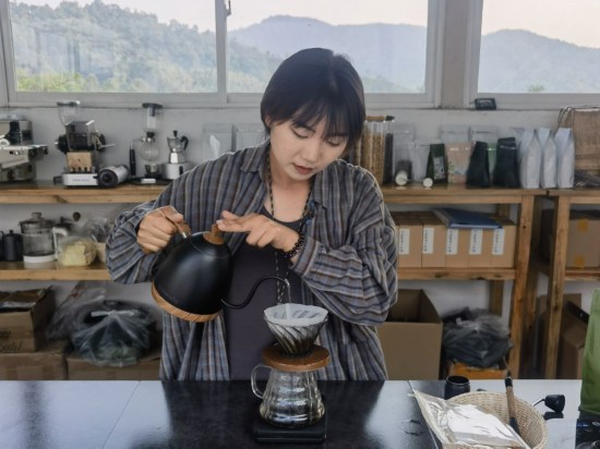 4月18日、雲南普洱市野鴨塘河谷コーヒー農園でドリップコーヒーを淹れる楊卓青さん。