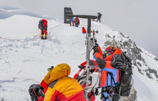 チョモランマの標高約8830メートル地点の自動気象観測所のメンテナンスをする科学調査隊員（5月23日、撮影・拉巴）。