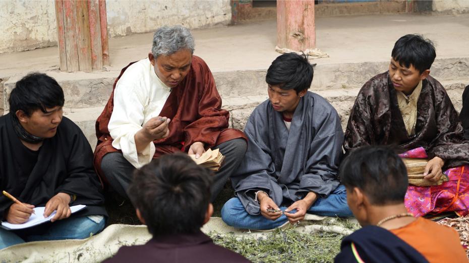 世襲されるホームドクターの「其木居曼巴」である丹松扎巴さん（写真左から2人目）が学生たちに薬浴に使用する薬草を見分ける方法を教える様子（写真提供・中国無形文化遺産保護センター）。