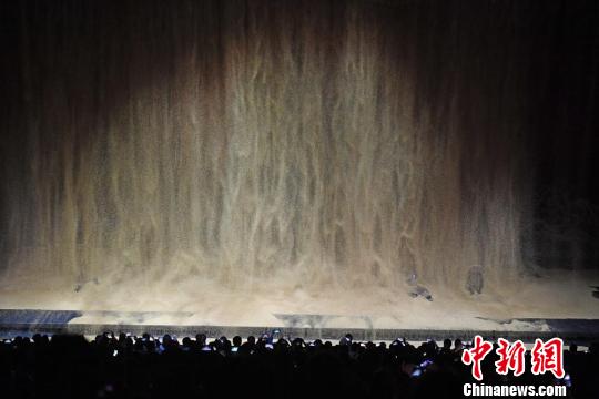 公演では400立方メートルの本物の砂が12メートルの高さから流れ落ちてくる幻想的なシーンが繰り広げられる（撮影・楊艶敏）。
