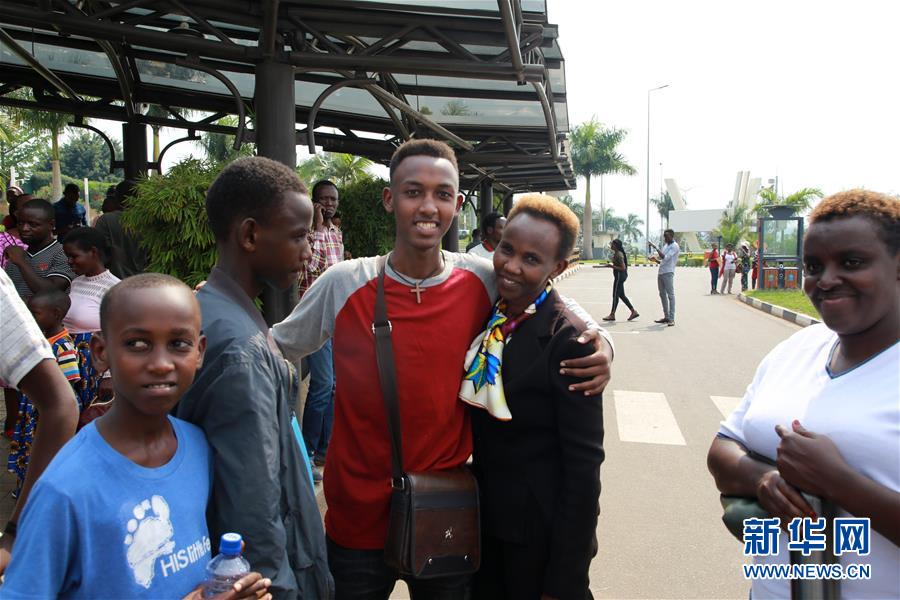 ルワンダのキガリ国際空港で9日、中国への出発を前に、親友との別れを惜しむルワンダ人の若者・マイク・マンツィさん（写真中央、撮影・呂天然）。