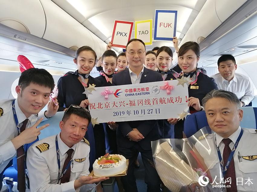 初就航を祝う東方航空福岡営業部の殷書健総経理とスタッフ、同便のフライトクルー。