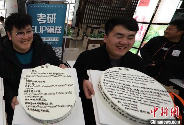 英語の文や数学の公式などが書かれた「暗記ケーキ」を見せる南京航空航天大学の大学生（撮影・泱波）。