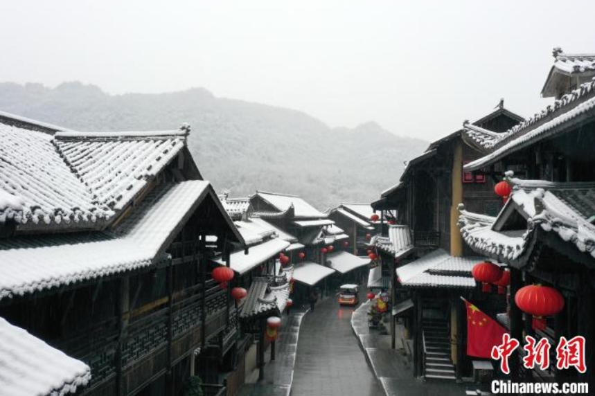 春の雪と絶妙なコントラストを見せる土家吊脚楼建築群（撮影・邱洪斌）。
