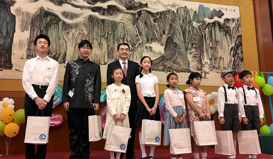 第11回「大使杯」中国語朗読大会の参加者に「国際子供の日」を祝うプレゼントを渡す呉江浩大使（撮影・許可）。
