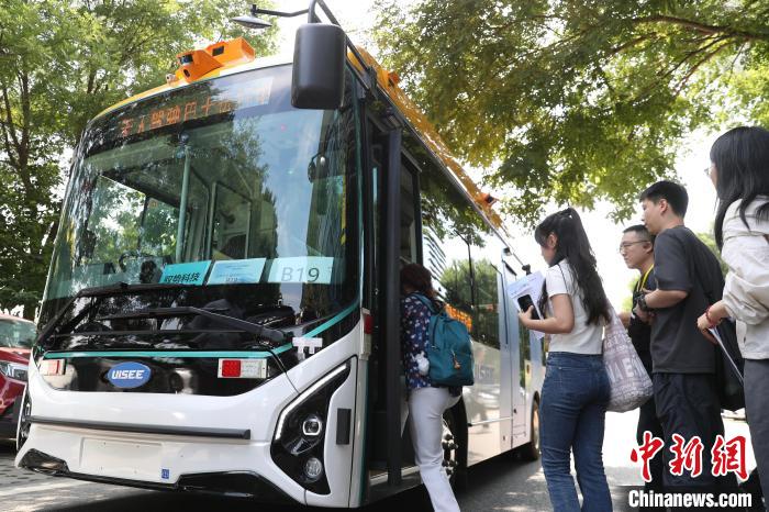 16日、北京市中関村新興産業先端技術研究院の構内で自動運転バスを体験する人々。撮影・王紫儒