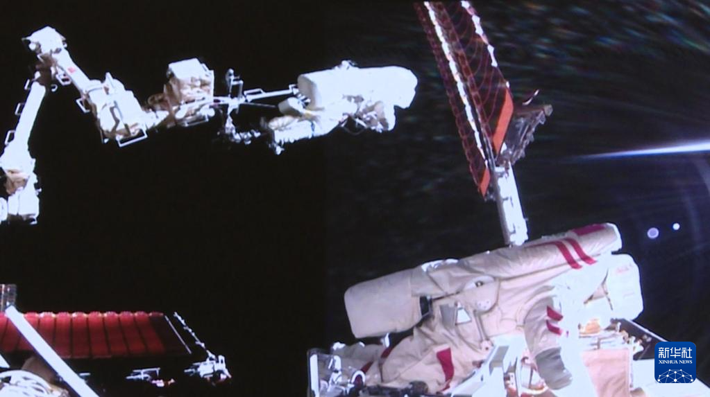 これは8月15日、北京宇宙飛行制御センターのスクリーンに映し出された、「神舟20号」の宇宙飛行士チームの陳冬氏（左）と王傑氏が船外で作業する様子（映像のスクリーンショット）。撮影・殷家捷