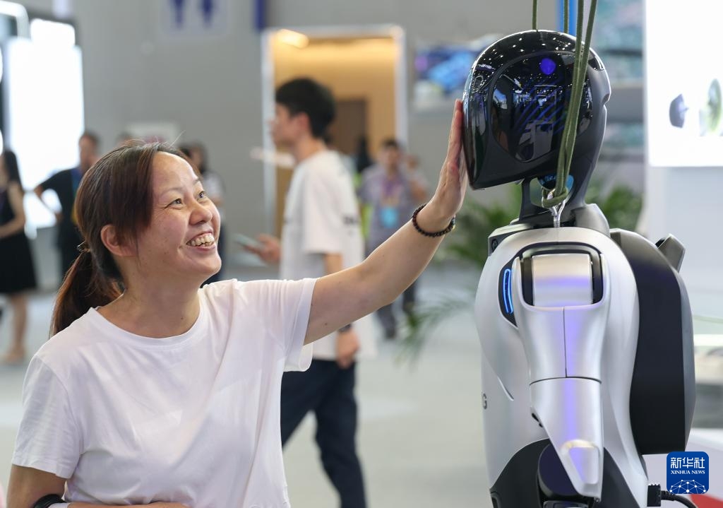 2025世界スマート産業博覧会で人型ロボットの顔に手を伸ばす来場者（9月5日撮影・陳誠）。