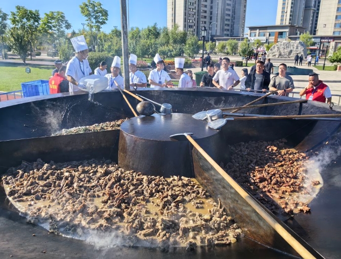 グルメエリアの大きな鉄鍋で煮込んだガチョウ料理（撮影・王君宝）。