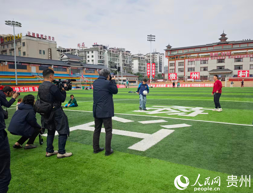 貴州省榕江県の「村超」の試合会場で選手と交流・取材するメディア団（撮影・龍章楡）。