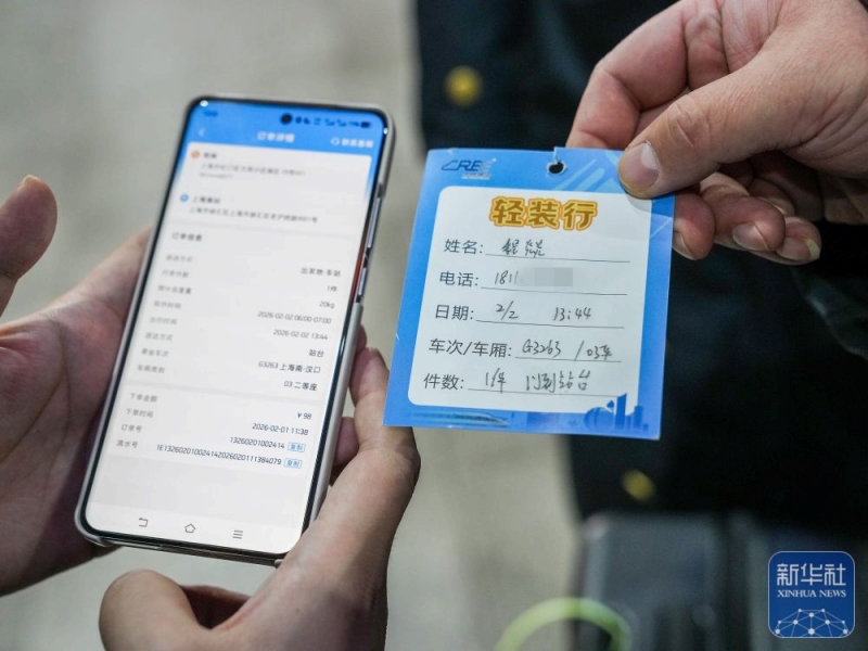 2月2日、スマホの情報と「身軽に旅行」サービスを利用して運ばれてきたスーツケースのラベルの情報を確認する程燚さん。