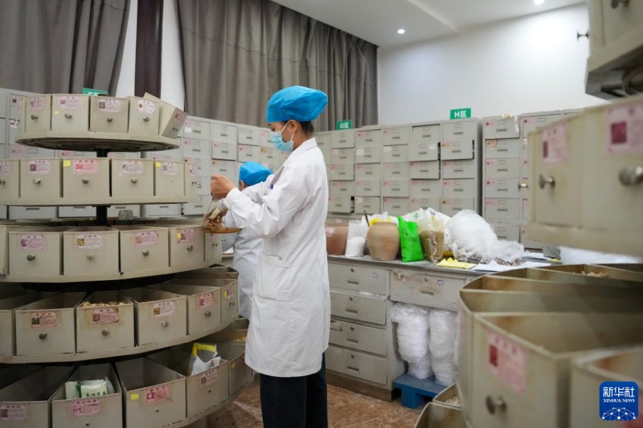 硯山県中医病院の調剤室で、生薬を調剤する薬剤師(7月30日撮影・陳欣波)。