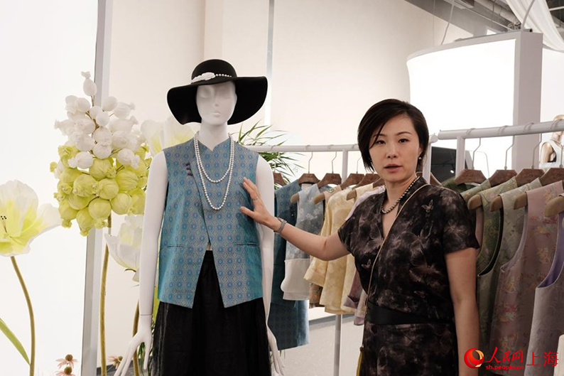 店内の「新中国スタイル」の服を紹介する田玲さん(撮影・葛俊俊)。