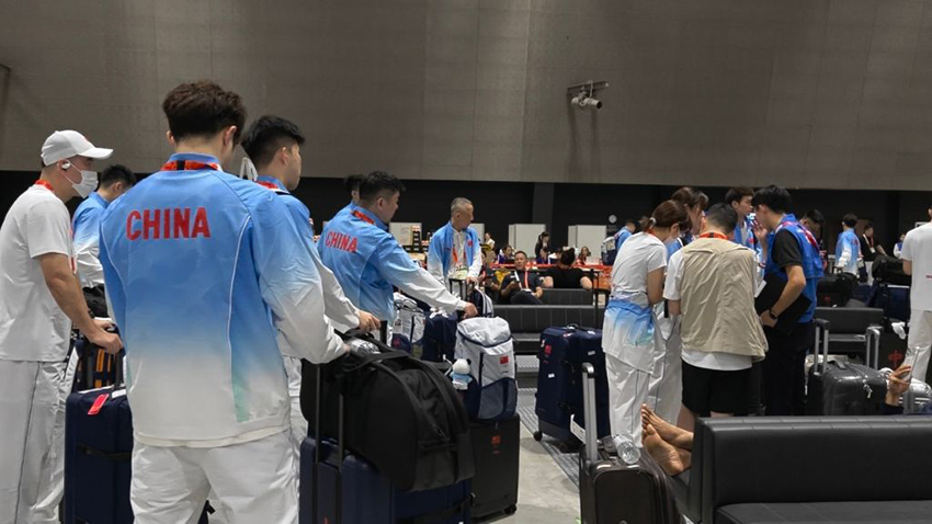 空港の交通センターでホテルに向かう方法を調べる中国のバドミントンチームのメンバー（撮影・趙紫羽）。