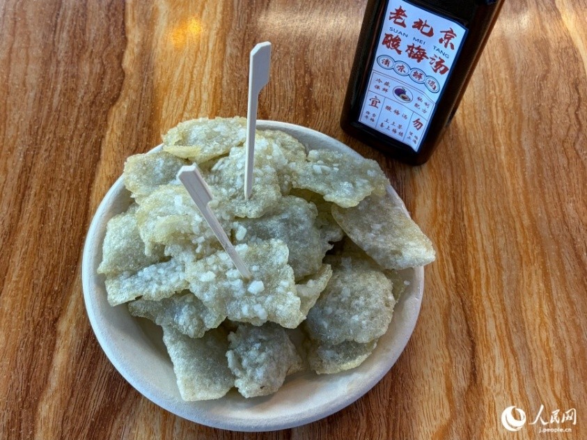 ニンニクテイストが口中に広がる揚げたてのでんぷんチップと酸梅湯（撮影・勝又あや子）